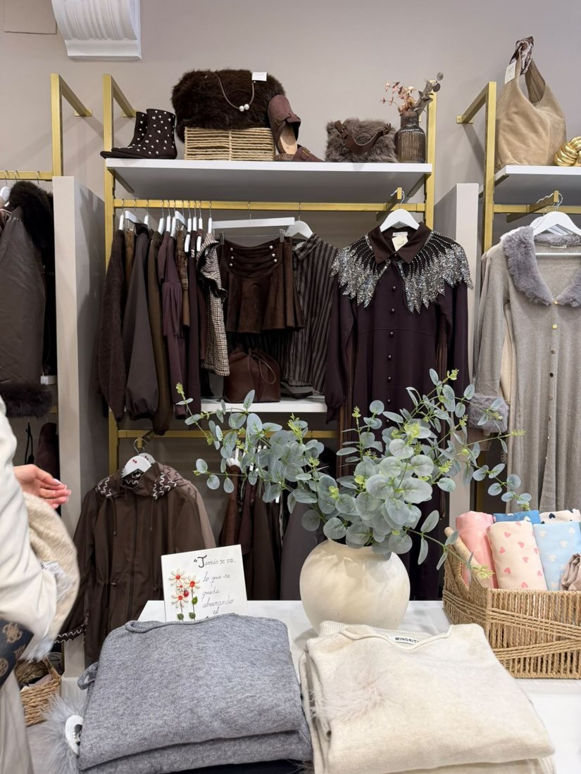 Pared de la colección en tonos chocolate: vestido con cuello de lentejuelas, botines con tachas y bolsos